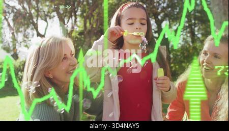 Blowing child in red top making soap bubbles in sunlit park with yellow wand, green overlays Stock Photo