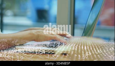 Typing adult hands pressing keys on laptop at desk beside large window, showing data overlay Stock Photo