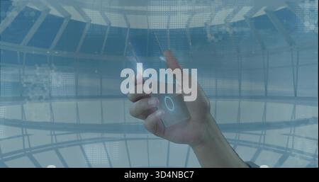 Holding right hand tapping device with glowing UI inside glass dome, thumb flare, wristband visible Stock Photo