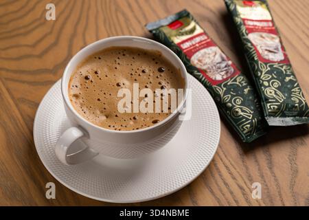 Lviv, Ukraine - November 11, 2025: Overhead View of Hot Cappuccino Cup and Jacobs Instant Sachets Stock Photo