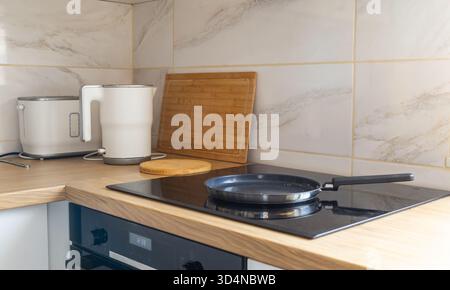 Modern kitchen corner with kettle and pan. Daily rituals, balance between function, order and warmth. Stock Photo