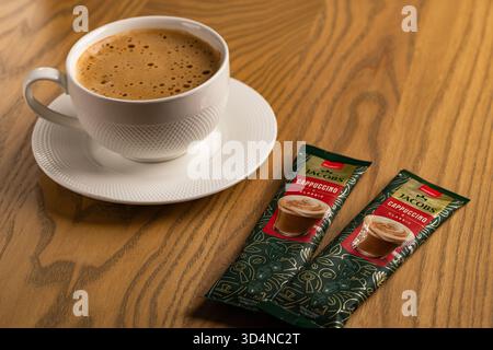 Lviv, Ukraine - November 11, 2025: Overhead View of Hot Cappuccino Cup and Jacobs Instant Sachets Stock Photo