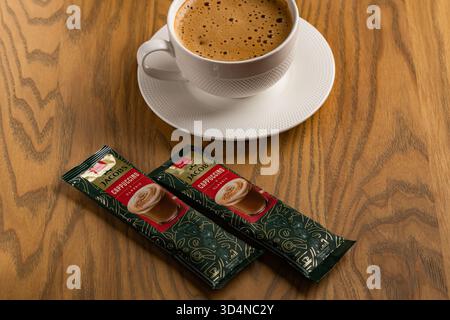 Lviv, Ukraine - November 11, 2025: Overhead View of Hot Cappuccino Cup and Jacobs Instant Sachets Stock Photo