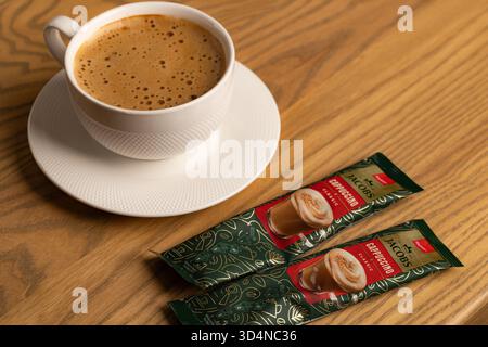 Lviv, Ukraine - November 11, 2025: Overhead View of Hot Cappuccino Cup and Jacobs Instant Sachets Stock Photo