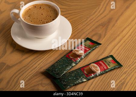 Lviv, Ukraine - November 11, 2025: Overhead View of Hot Cappuccino Cup and Jacobs Instant Sachets Stock Photo