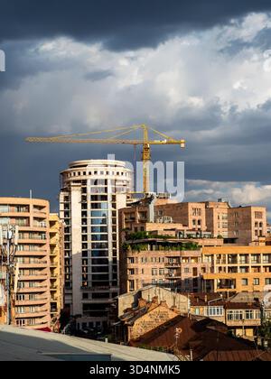 dark gray rainy clouds over sunlit urban houses in Yerevan city, Armenia on summer day Stock Photo