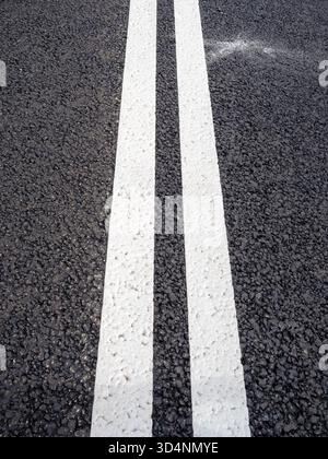 above view of freshly applied road markings - double solid line on new asphalt surface of city highway Stock Photo