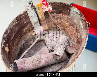 few dried used paint rollers in plastic bucket Stock Photo