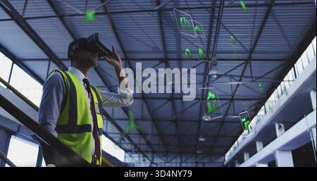 Inspecting engineer wearing hi-vis vest, tie, using VR headset with holo UI in hangar, copy space Stock Photo