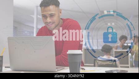Leaning man wearing red top typing on laptop at office, coffee cup, padlock overlay, copy space Stock Photo