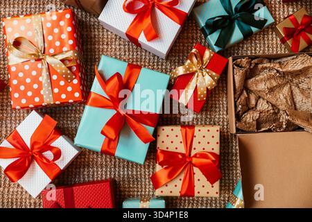 Top view of colourful gift boxes with red ribbons on the floor. Stock Photo