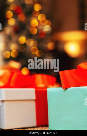 Close-up of gift boxes against a background of defocused Christmas lights. Stock Photo