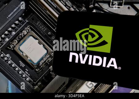 NVIDIA logo displayed on smartphone in front of GeForce graphics card Stock Photo