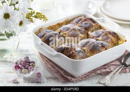 Food, Bread and butter hot cross buns pudding in white baking dish, selective focus Stock Photo