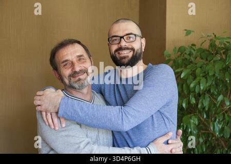 Portrait of happy smiling father and his adult son. Man hugging his elderly father. Father's day concept Stock Photo
