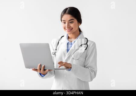 Cheerful Young Medical Worker in Uniform Helps Patients Using Technology at Clinic Stock Photo