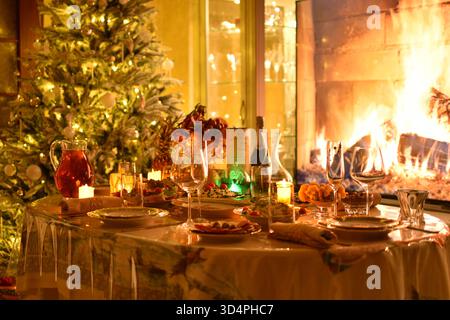 Luxury Christmas dinner table with fireplace and Christmas tree Stock Photo