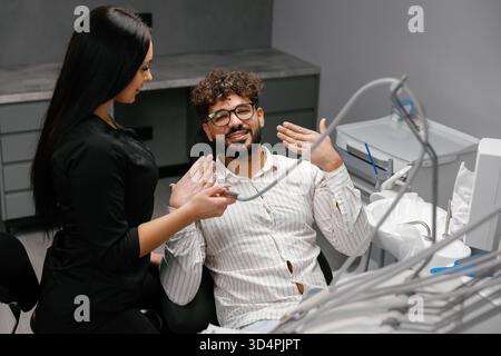 Dentist and happy patient showing teeth after successful dental check-up, promoting oral healthcare and a healthy smile Stock Photo