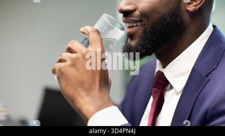 Unrecognizable black businessman drinking water, copy space Stock Photo