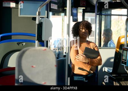 Young woman commuting on city bus holding tablet Stock Photo