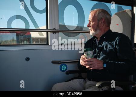 Senior man commuting on bus, looking out window Stock Photo