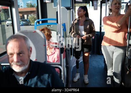 Young woman with prosthetic leg commuting on bus Stock Photo