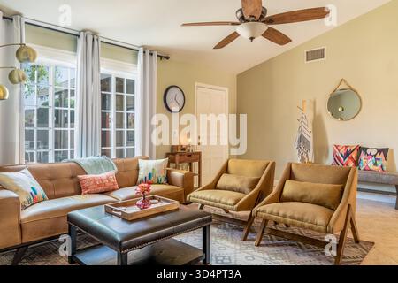 Living room interior with mid-century modern furniture, couch, sofa, chairs, table, and windows Stock Photo