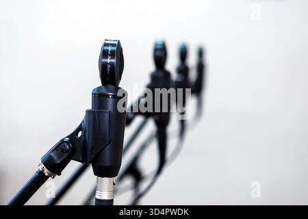 Close-up of microphones in a studio, capturing sound with precision, surrounded by cables and equipment under controlled lighting for recording music Stock Photo