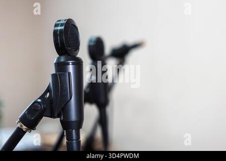 Close-up of microphones in a studio, capturing sound with precision, surrounded by cables and equipment under controlled lighting for recording music Stock Photo