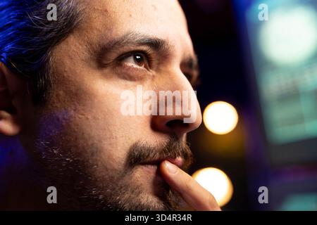 Close up of hacker focused on getting undetectable virus past antivirus protection. Cybercriminal in secret hideout concentrating on developing data mining script to breach firewalls Stock Photo