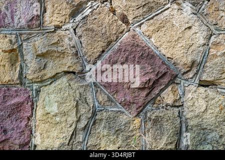 The abstract patterns of stones cemented into an exterior wall Stock Photo