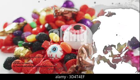 Showing sugar-coated gummies and novelty plastic eyeballs on white tabletop, halftone overlay Stock Photo