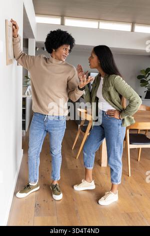 Standing couple having serious discussion in modern dining area, with wooden picture frame Stock Photo