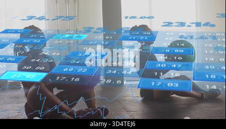 Sitting two women holding legs on mats at fitness studio, wearing sportswear, HUD overlay Stock Photo