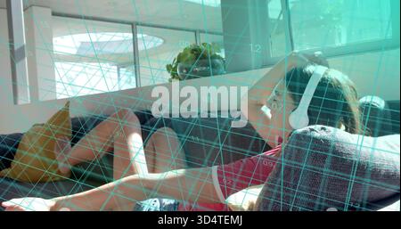 Reclining woman in red shirt listening with white headphones resting on gray sofa amid teal grid Stock Photo
