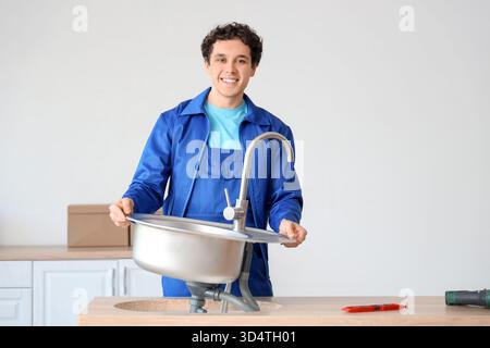 Male worker installing sink in kitchen Stock Photo