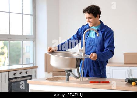 Male worker installing sink in kitchen Stock Photo
