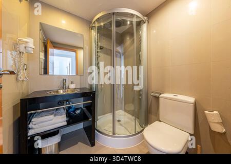 Small modern bathroom with shower cabin and toilet in mediterranean home Stock Photo