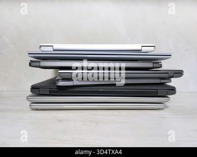 stack of laptops on a gray background, on the table, laptop computer, tablet, business, work, remote work, freelance. Stock Photo