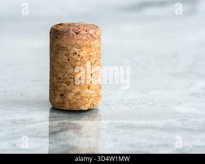 Wine cork standing on polished marble surface with reflection. Stock Photo