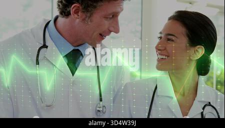 Talking two doctors consulting in clinic, with stethoscopes, white coats, ECG grid overlay Stock Photo