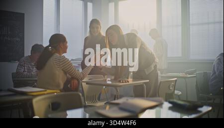 Teen Girls Record Fun Dance Video During Classroom Break, Laughing and Enjoying Creative Moment Together. Concept of Youth Culture, Social Media Trends, and Creative Expression in Modern School Life. Stock Photo