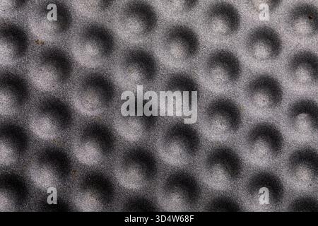 Close-up of a gray surface featuring repeating circular indents, ideal for backgrounds, design, and industrial concepts. Stock Photo
