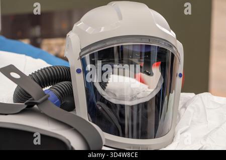 A modern safety helmet with a transparent shield and flexible ventilation hoses Stock Photo