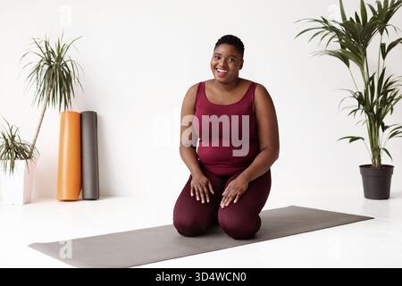 Happy Yoga Instructor Welcomes Students to Morning Class in Bright Studio Setting Stock Photo