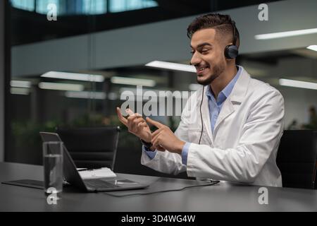 Handsome Young Middle Eastern Scientist Engaged in Video Chat in Modern Laboratory Setting Stock Photo