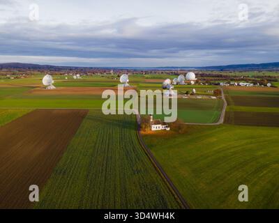 Raisting, Germany - 11 November 2025: Aerial view of the Raisting Earth Station's stark white satellite dishes puncturing the Bavarian green fields un Stock Photo