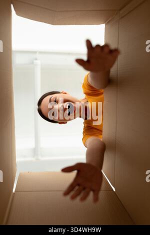 Happy Woman Unboxing Delivery in Her Home, Excited to See New Items Inside Carton Box Stock Photo