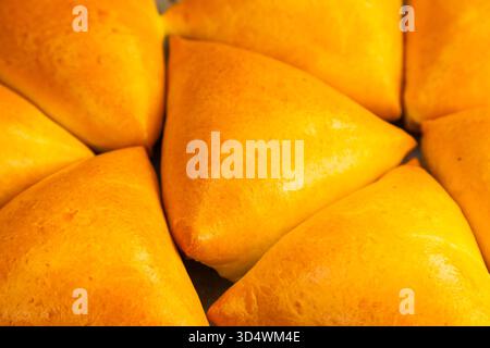 Homemade baked triangular buns lie on white parchment Stock Photo