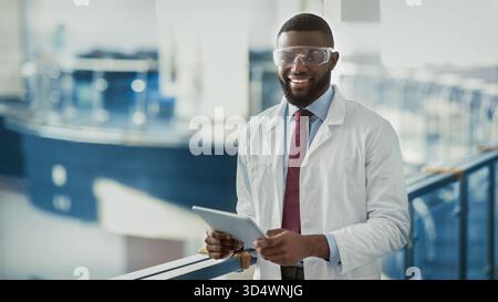 Happy young black medical scientist using digital tablet Stock Photo
